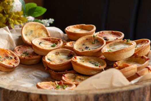 Plateau de mini tartelettes salées garnies, prêtes à être partagées lors d'un apéritif convivial.