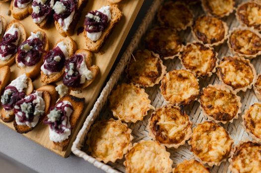 Plateau d'amuse-bouches apéritifs avec feuilletés au fromage et tartines garnies de fromage et confiture.